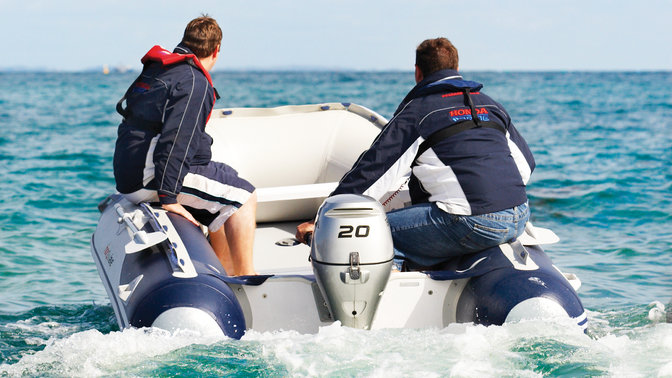 Bateau gonflable Honda, utilisé par des démonstrateurs, sur le littoral.
