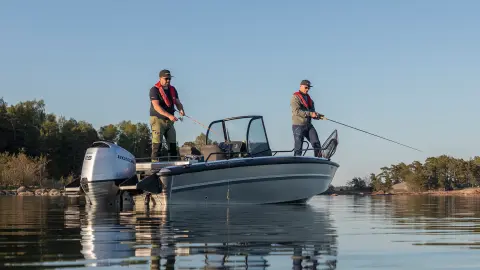 Des hommes en train de pêcher sur un bateau dans un lac. 