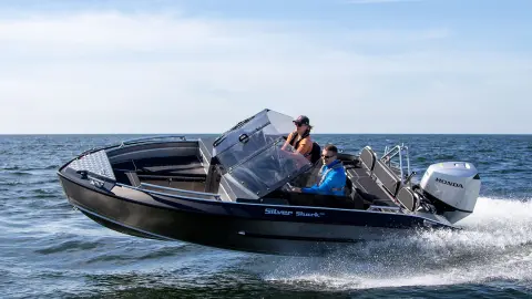 Couple sur un bateau Silver Shark utilisant un moteur Honda. 