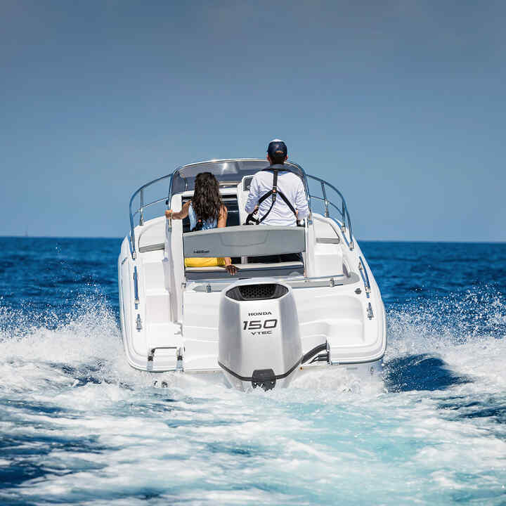 Couple en mer sur un bateau équipé d'un moteur Honda BF150.