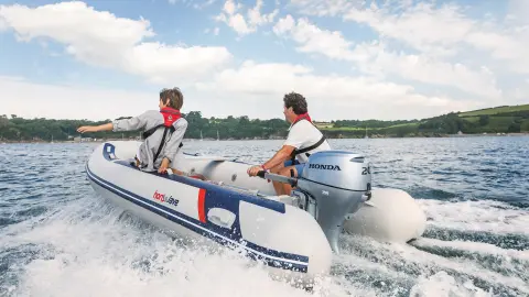 Deux hommes sur un Honwave, équipé d’un moteur BF20 dans l’eau. 