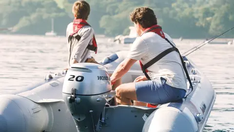 Deux hommes sur un Honwave, équipé d’un moteur BF20 à proximité d’un lac.