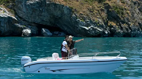 Couple sur une petite embarcation au bord d’un lac, équipée d’un moteur Honda BF.