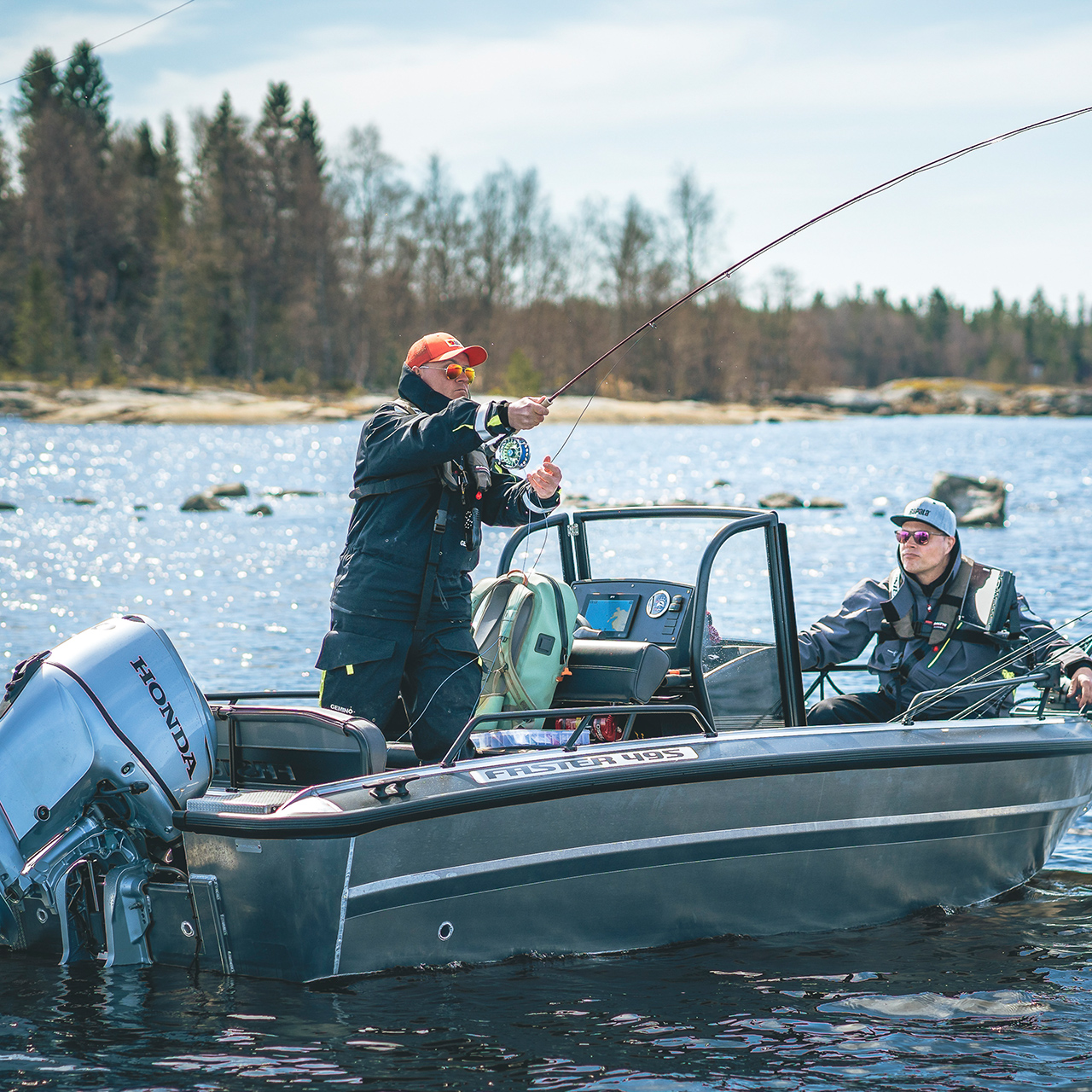 Hommes pêchant depuis un bateau équipé d’un moteur Honda BF30 sur un lac.