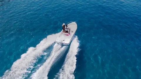 Couple sur un bateau dans l'océan avec un moteur Honda BF.