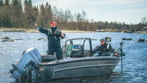 Deux messieurs sur un bateau de pêche, équipé d’un moteur Honda BF60 au bord d’un lac. 