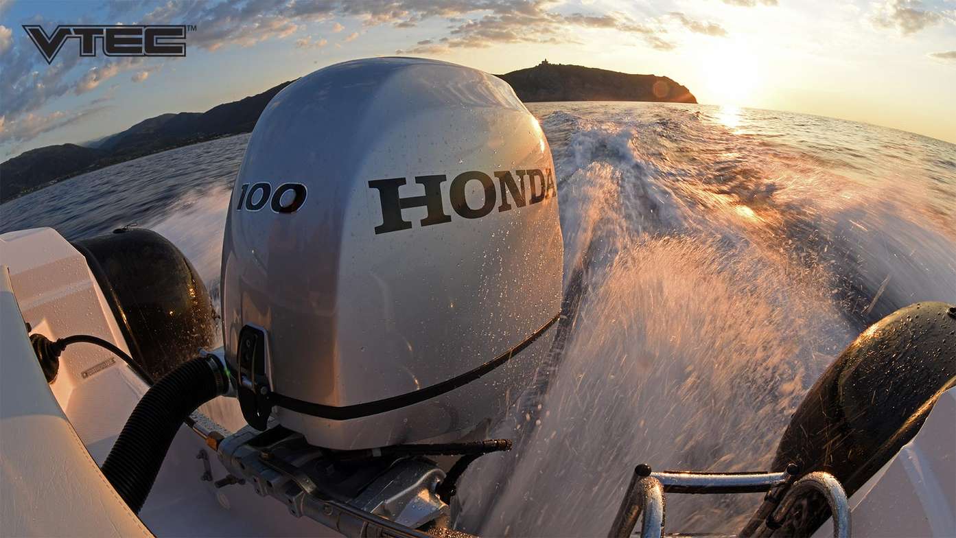 Coucher de soleil depuis l'arrière d'un bateau avec vue sur un moteur hors-bord Honda BF 100