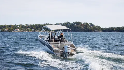 Mannequin conduisant un bateau équipé du moteur BF80-100 en mer.